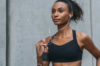 Sağlıklı genç bir kadının, sabah şehir sokaklarında koşarkenki yakın çekimi.