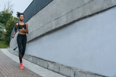 Uzun menzilli bir görüntü, kadın sporcu sabah dışarıda egzersiz yapıyor.