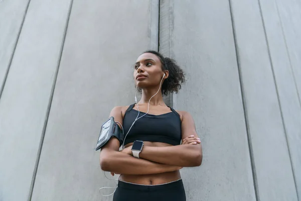 Zelfverzekerde Sportvrouw Met Koptelefoon Staat Met Haar Handen Gekruist Kijkt — Stockfoto