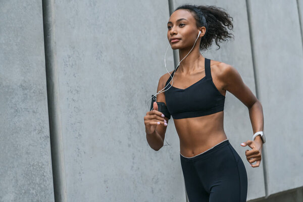 Healthy young woman running in morning outdoors at city streets