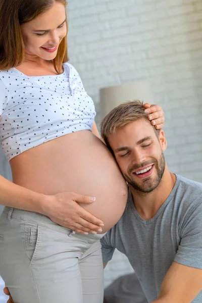 Vertikalt Bilde Kjekk Mann Som Lytter Til Sin Vakre Gravide – stockfoto