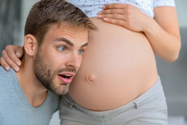 Bonito Homem Está Ouvindo Barriga Sua Bela Esposa Grávida Animado — Fotografia de Stock