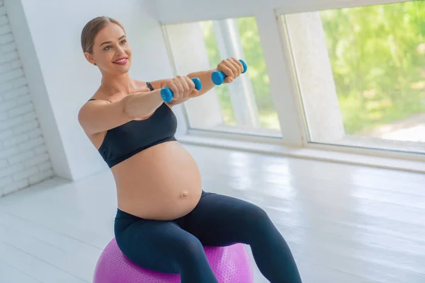 Genç Hamile Bir Kadın Evde Halterlerle Spor Salonuyla Egzersiz Yapıyor — Stok fotoğraf