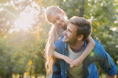 Kızını sırtında taşıyan bir adamın yakınına.