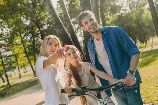 Liten Leende Flicka Lär Sig Att Cykla Med Sina Föräldrar — Stockfoto