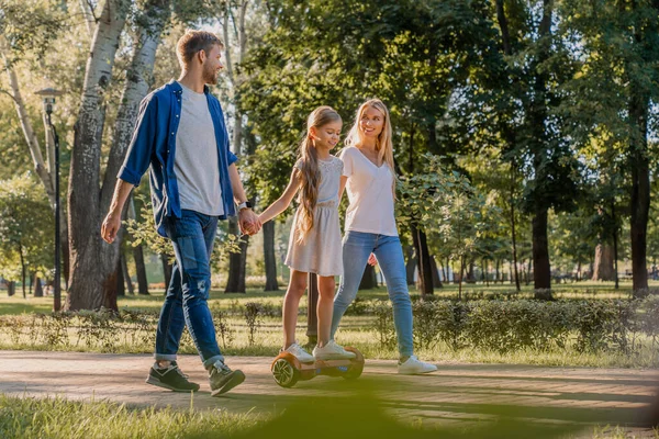 Küçük Şirin Kızlarıyla Parkta Yürüyen Gülümseyen Ebeveynlerin Yan Görüntüsü — Stok fotoğraf