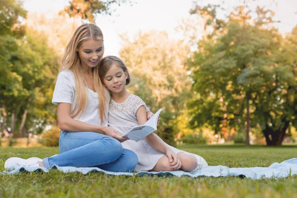 Anya Aranyos Kislányával Könyvet Olvas Parkban — Stock Fotó