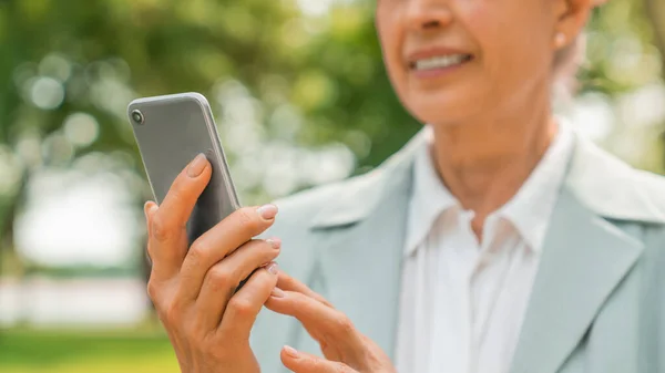Przycięte Ujęcie Uśmiechniętej Białej Starszej Kobiety Korzystającej Telefonu Komórkowego Zewnątrz — Zdjęcie stockowe