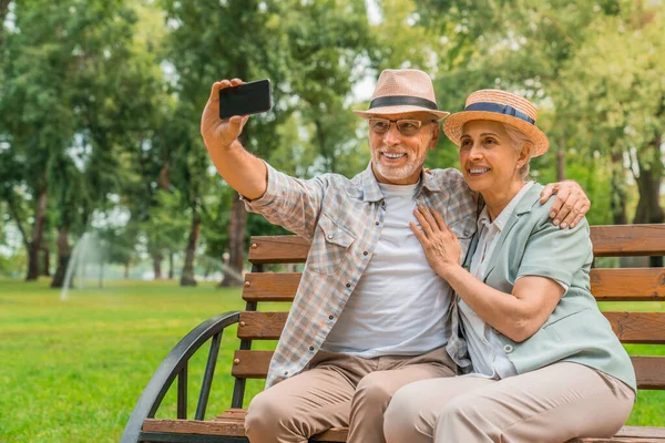 Pareja Mayor Sombreros Abrazando Tomando Una Selfie Teléfono Móvil Mientras — Foto de Stock