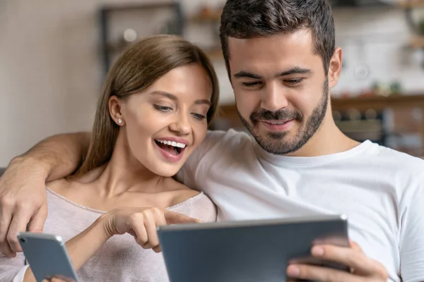 Genç Mutlu Çiftin Evdeki Kanepede Otururken Sarılıp Akıllı Telefon Dijital — Stok fotoğraf