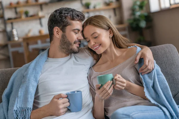 Neşeli Kucaklaşan Romantik Çift Kanepede Oturmuş Çay Içiyorlar — Stok fotoğraf