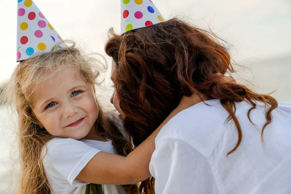 Close Shot Mother Daughter Wearing Party Hats Hugging While Sitting — Stock Photo, Image