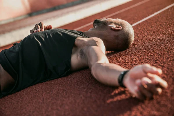 Close up of a tired athlete relaxing after a run.