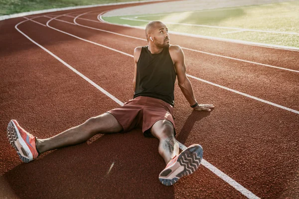 Hombre Atleta Relajante Sentado Pista Del Estadio Escuchando Música — Foto de Stock