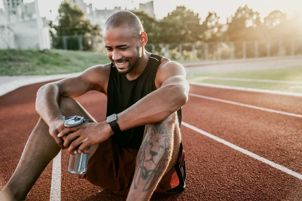 Jovem Desportista Alegre Sentado Pista Corrida Estádio Com Garrafa Água — Fotografia de Stock