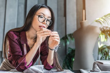 Genç moda tasarımcısı galerisinde iğne kullanıyor.