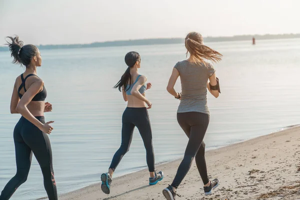 Zadní Pohled Skupina Sportovních Žen Běží Pláži — Stock fotografie