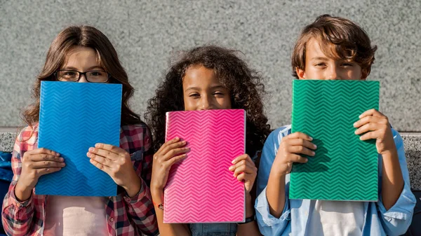 Niños Escuelas Multiétnicas Felices Sosteniendo Cuadernos Cerrando Caras Divirtiéndose Las — Foto de Stock