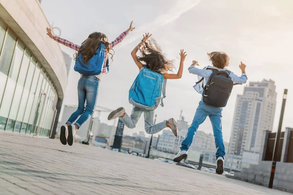 Вид Сзади Группу Энергичных Учеников Начальной Школы Прыгающих Веселящихся Школьном — стоковое фото
