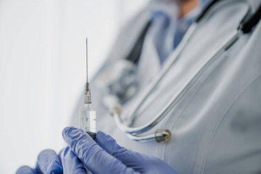 Kadın doktorun elinde şırıngayla hastanede kesilen görüntüsünü kapatın.