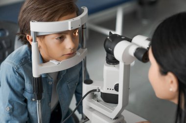 Modern klinikte göz muayenesi yapan kadın doktor.