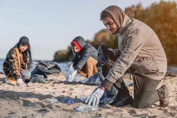 Bonito Jovem Voluntário Com Equipe Reunindo Lixo Praia — Fotografia de Stock