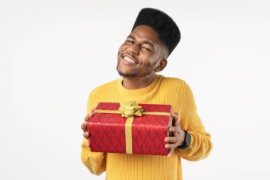 Beyaz arka planda izole edilmiş günlük sarı süveter giyen gülümseyen Afro-Amerikan bir adam.