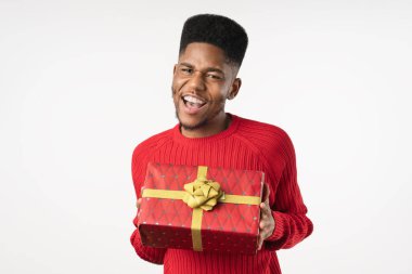 Beyaz arka planda izole edilmiş mevcut kutusuyla gündelik giyinmiş neşeli Afrikalı Amerikalı adam.