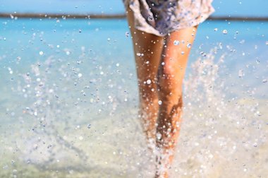 Genç slim fit kadın su yapma bacakları ile su sıçramalarına. Tatil ve yaz ruh hali