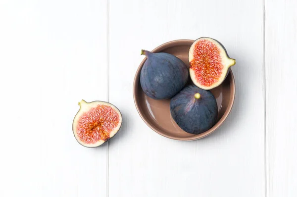 Top flat view: fresh figs on white wooden table