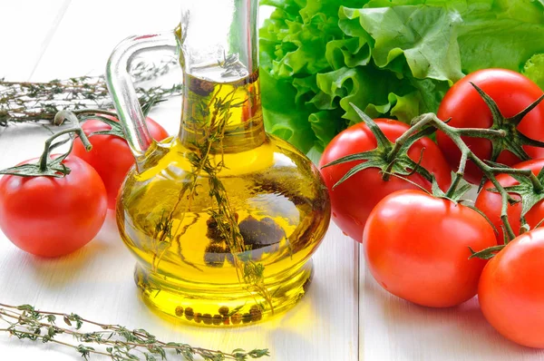 Aceite de oliva y tomates sobre mesa de madera blanca — Foto de Stock