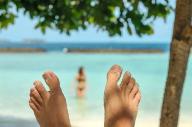 Adam ayak plaj üzerinde bulanık kadın üzerinde. Seyahat ve tatil kavramı