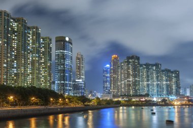 Geceleri Hong Kong 'da deniz kenarındaki yüksek katlı konut binası.