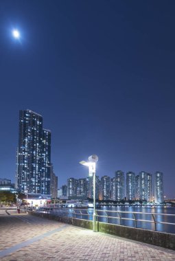 Geceleri Hong Kong 'da yüksek binalar ve limanlar.