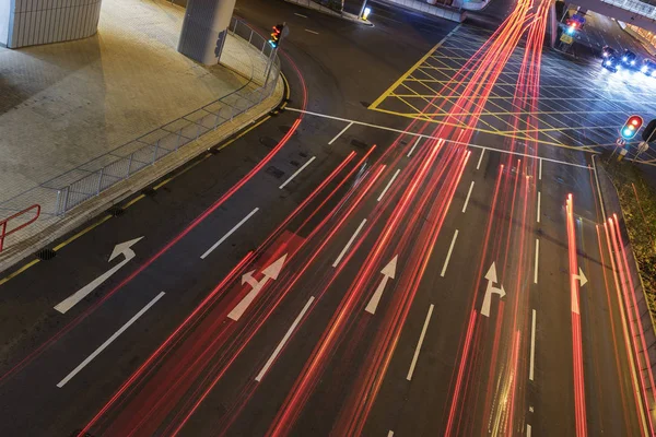 Traffico notturno su strada. Segno freccia bianca dipinta su asfalto nero con sentiero leggero — Foto Stock