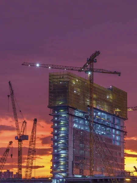 Grúa en el sitio de construcción para edificios de gran altura bajo la puesta del sol — Foto de Stock