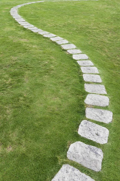 Stenvägen på grönt gräs. Naturlig bakgrund — Stockfoto