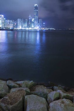 Geceleri Hong Kong şehrinin silueti ve limanı.
