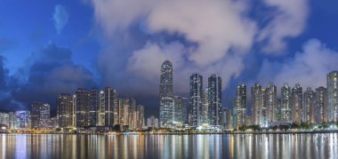 Ufuk çizgisi manzarası ve Hong Kong şehir merkezinin limanı alacakaranlıkta.