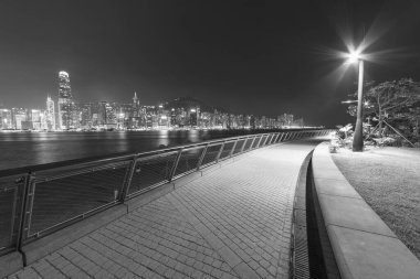 Geceleri Hong Kong şehrinin deniz kenarında gezinti ve ufuk çizgisi