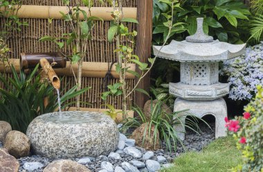 Japon bahçesinde taş fener ve bambu çeşmesi