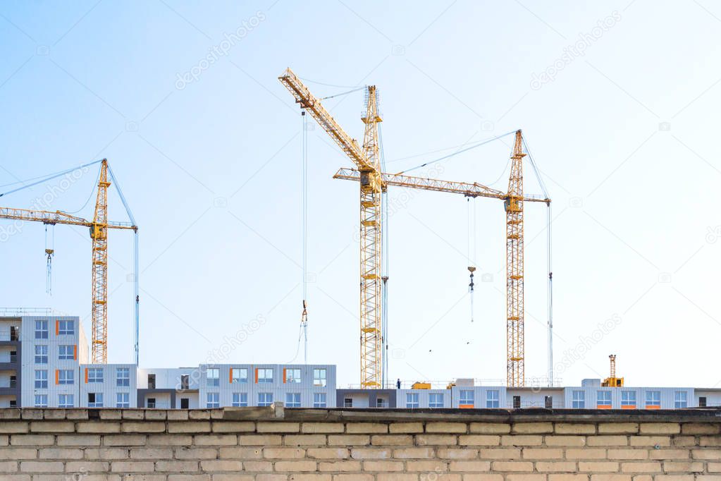 Cranes and building behind the fence