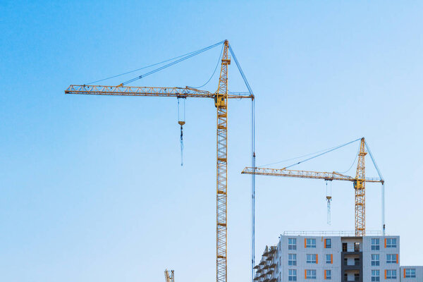 Industrial construction site with tower cranes and building