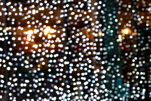 Guirlandas desfocadas com bokeh. Luzes de Natal nas janelas — Fotografia de Stock