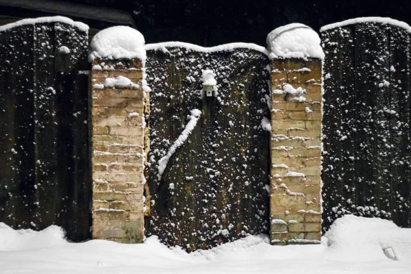 Snötäckta trästaket och dörren på vintern — Stockfoto