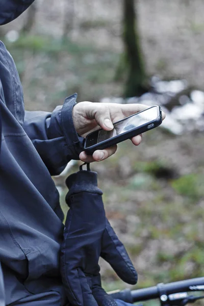 Man handen håller smart telefon i skogen — Stockfoto