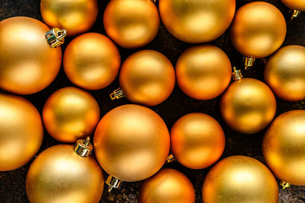 Christmas Flat Lay, new year background. Gold baubles on Dark Background. Selective focus. Minimalistic design