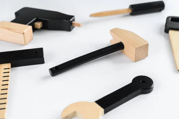 Instrumentos de madera para niños sobre fondo blanco, un martillo en el centro de la composición. El concepto de bricolaje . —  Fotos de Stock