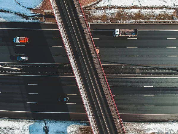 Vista aérea de carretera y puente, tráfico por carretera, bosques y campos cubiertos de nieve, invierno. Rusia, San Petersburgo . — Foto de stock gratis