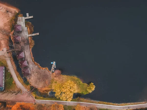 Vista aérea da floresta e lago azul. Casa de sauna junto à margem do lago. Cais de madeira com barcos de pesca. São Petersburgo, Rússia . — Fotografia de Stock